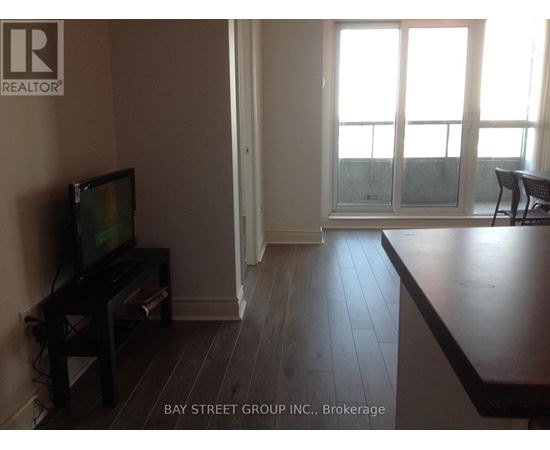 A living room with a television and sliding glass doors.