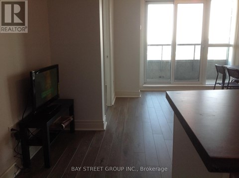 A living room with a television and sliding glass doors.