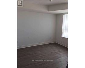 A room with a wooden floor and a window with blinds.