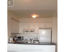 A kitchen with white cabinets and a white fridge.
