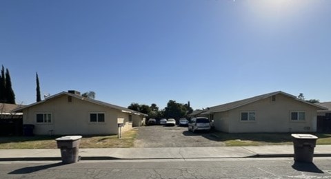 A sunny day in a residential area with houses and cars.