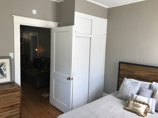 A bedroom with a bed, a dresser, and a wardrobe.