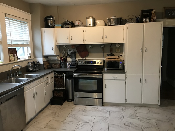 A kitchen with white cabinets and stainless steel appliances.