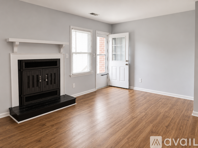 A room with a fireplace and wooden floors.