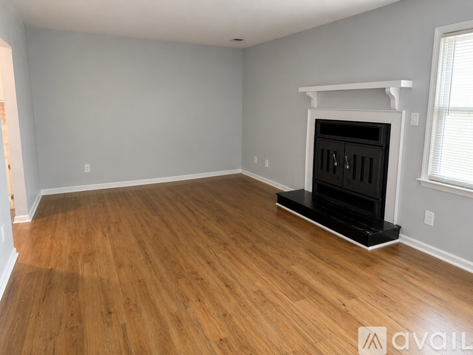 A room with a fireplace and wooden flooring.