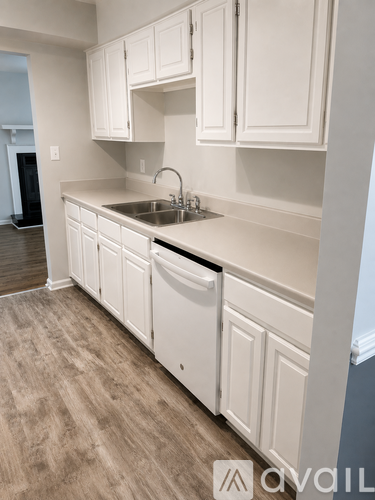A kitchen with white cabinets and a sink.