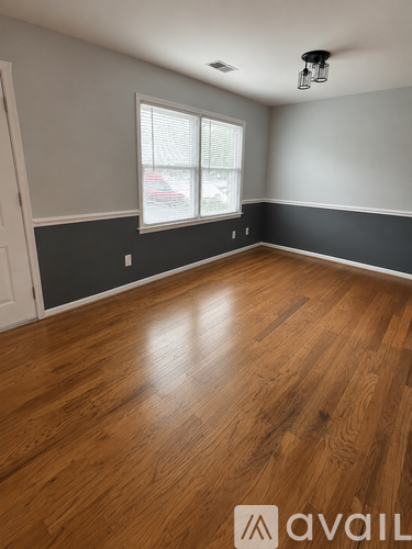 A room with wooden flooring and a window.
