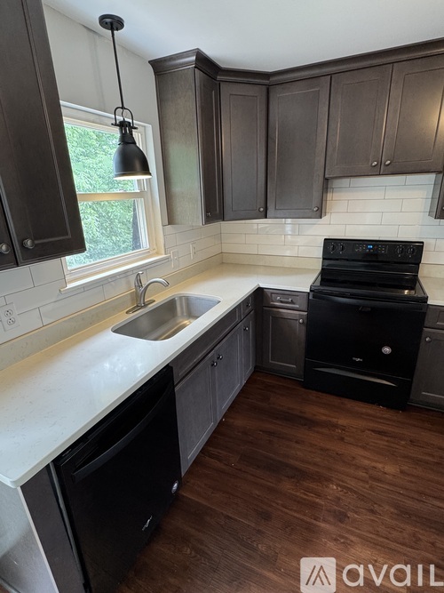 A kitchen with dark brown cabinets and a black stove top oven.