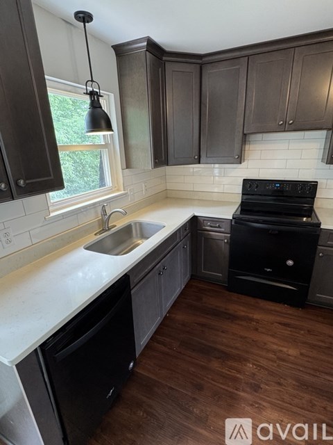 A kitchen with dark brown cabinets and a black stove top oven.