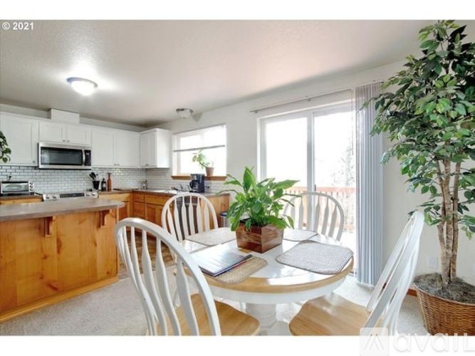A kitchen with a table and chairs.