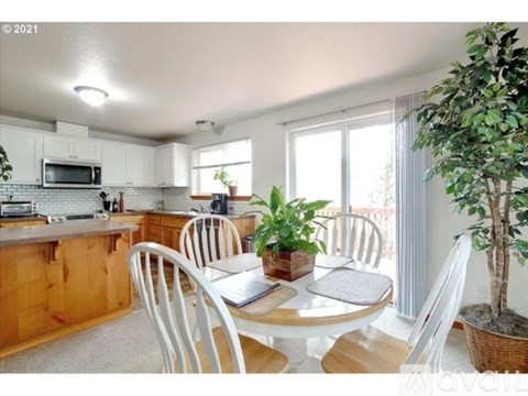 A kitchen with a table and chairs.