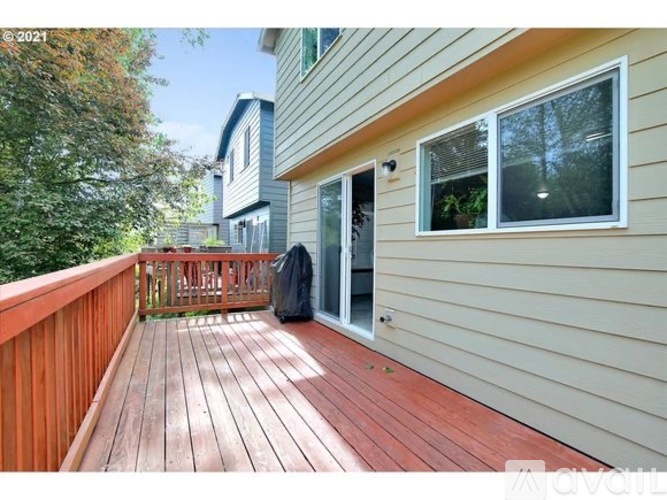 A wooden deck with a railing and a trash bag on it.