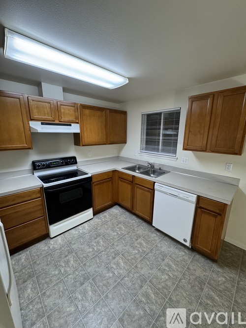 A kitchen with wooden cabinets and a black stove top oven.