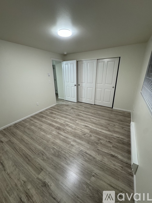 A room with wooden flooring and a white door.