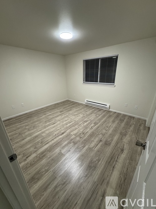 A room with wooden flooring and a window.