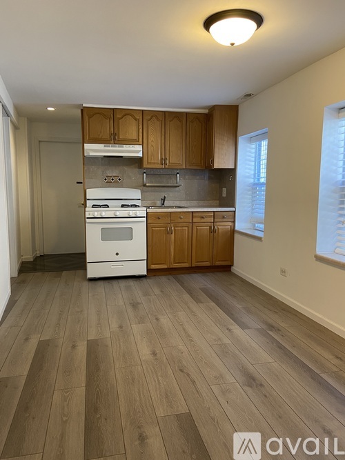 A kitchen with wooden cabinets and a white stove top oven.
