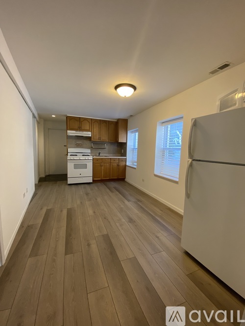 A kitchen with a refrigerator, oven, and cabinets.
