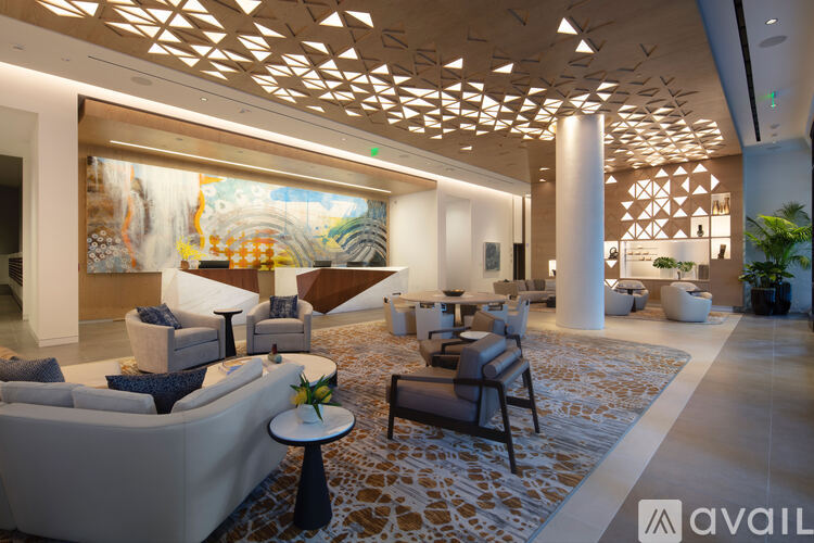 A spacious waiting area with a large painting on the wall and comfortable seating.