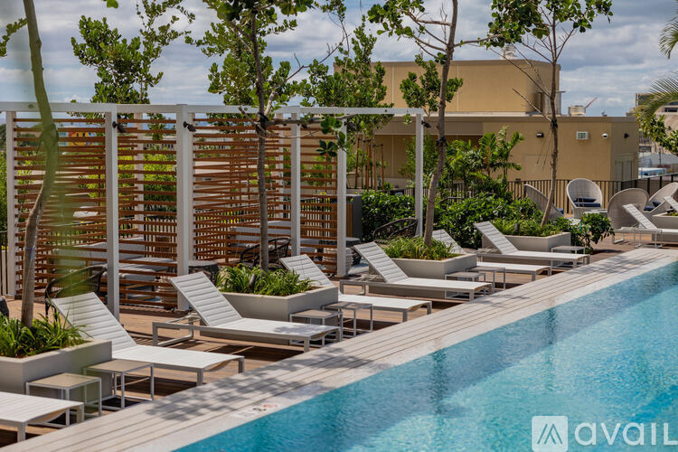 A pool area with sun loungers and a trellis.