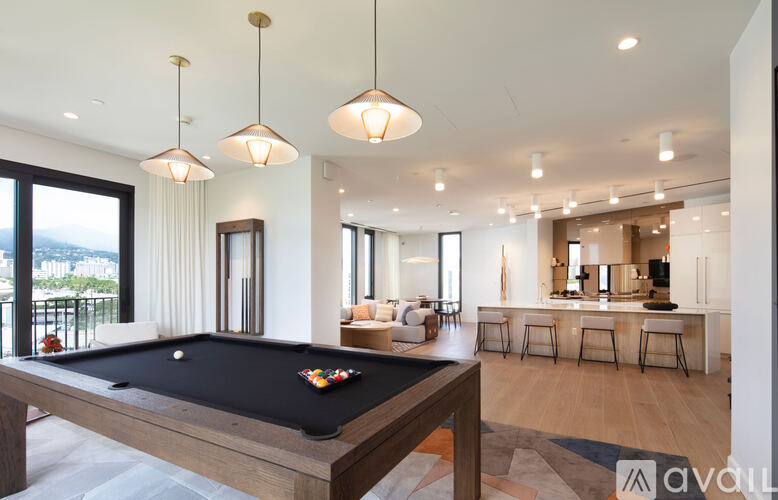 A pool table is in the middle of a living room.