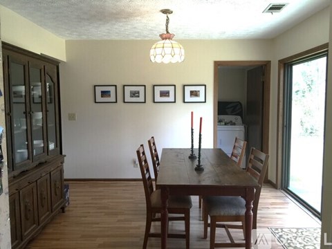 A dining room with a wooden table and chairs.