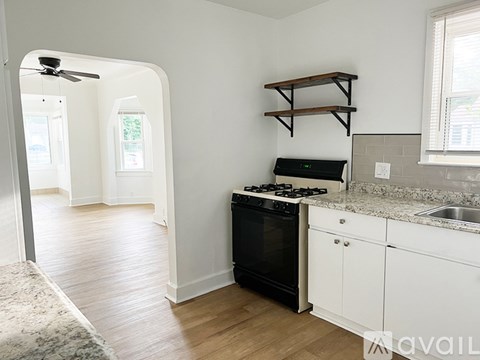 A kitchen with a black stove top oven and white cabinets.