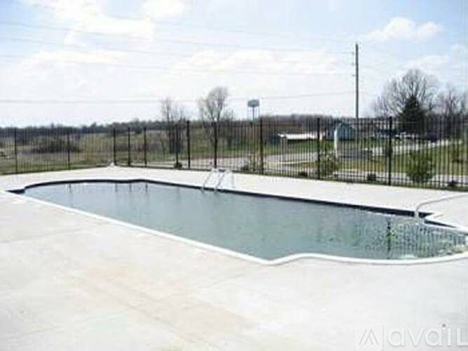A large empty swimming pool surrounded by a fence.