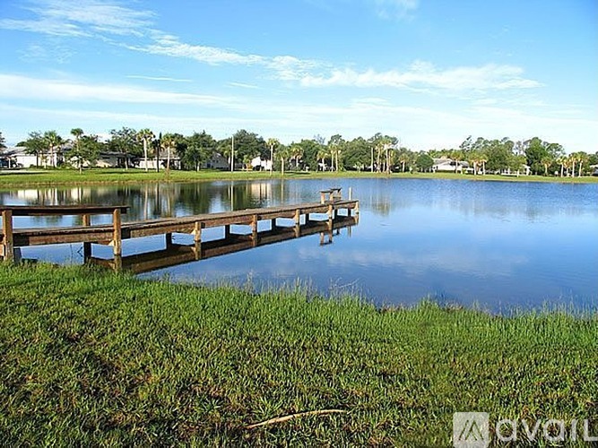 A wooden dock extends into a calm body of water.