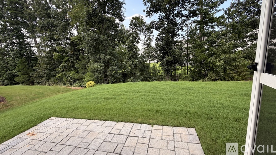 A backyard with a patio and a grassy area.