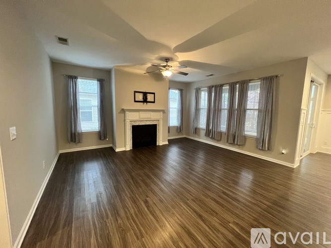 A living room with wood flooring and a fireplace.