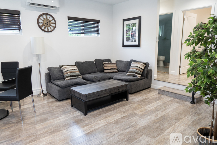A living room with a grey sofa and a wooden floor.