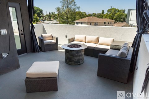 A patio with a couch, chairs, and a table.