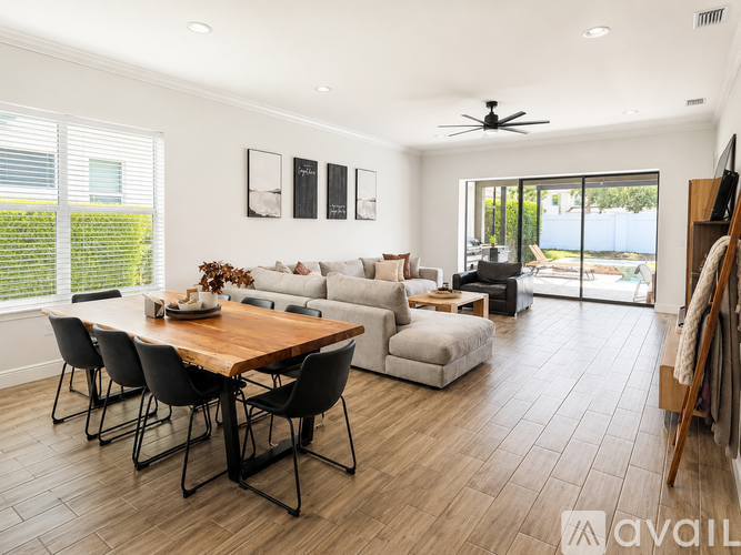 A modern living room with a wooden dining table and chairs.