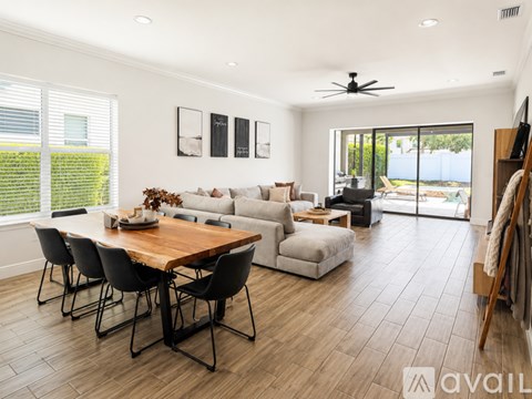 A modern living room with a wooden dining table and chairs.