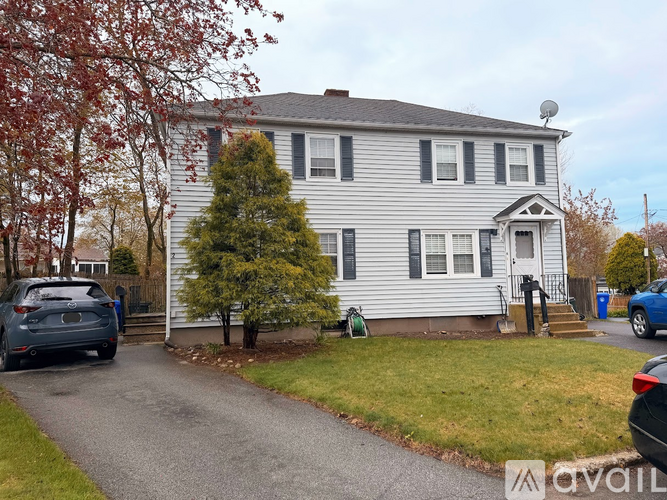 A two-story house with a grey exterior and a white door.