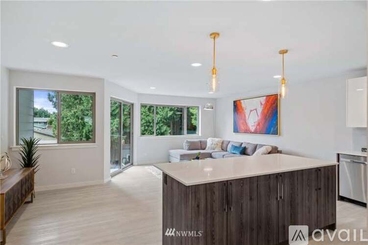 A modern kitchen with a large island and pendant lights.