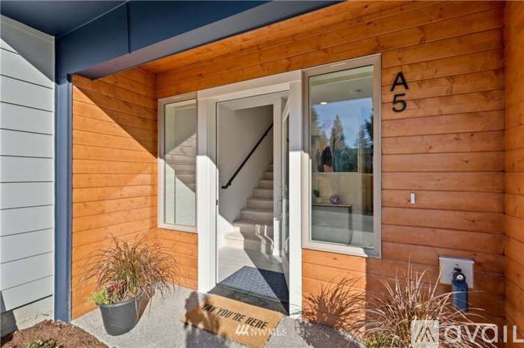 A wooden building with a glass door and a sign on the ground.