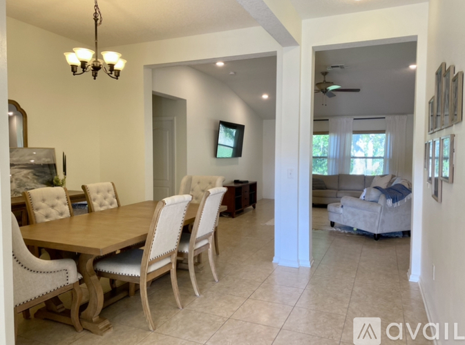 A dining room with a wooden table and chairs.
