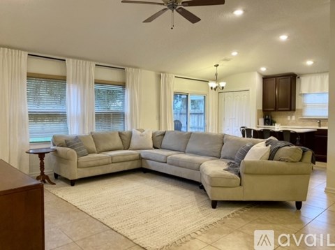 A living room with a beige sofa and a rug.