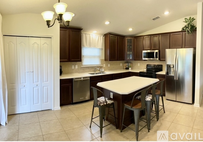 A kitchen with a table and chairs in the middle of it.
