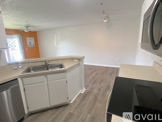A kitchen with white cabinets and a stainless steel dishwasher.