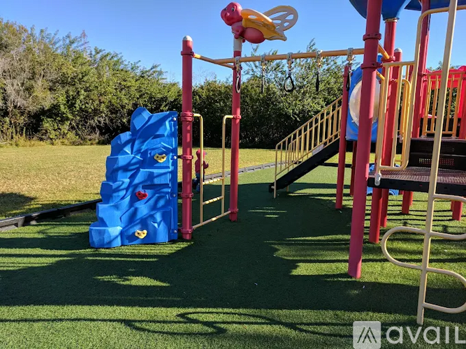 A playground with a blue climbing frame and a slide.
