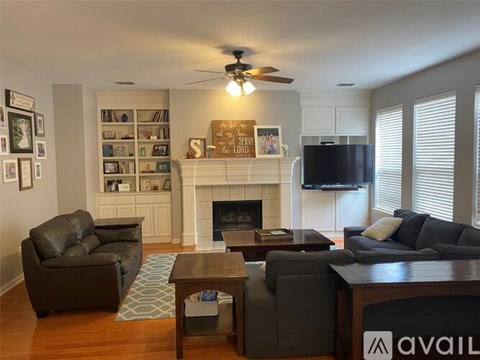 A living room with a fireplace, a couch, a chair, and a coffee table.