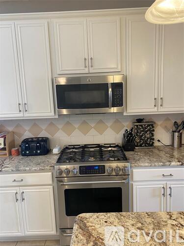 A kitchen with a stove top oven and a microwave above it.