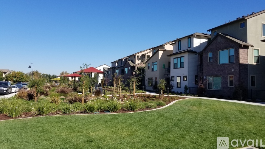 A row of houses with a grassy area in front.