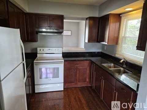 A kitchen with a white oven and black countertops.