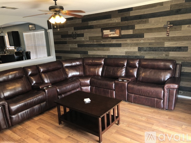 A brown leather sectional sofa with a coffee table in front of it.