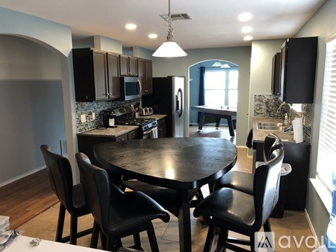 A modern kitchen with a large table and chairs.