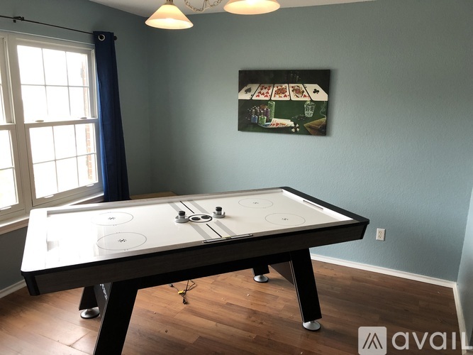 A pool table in a room with a painting on the wall.