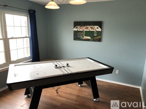 A pool table in a room with a painting on the wall.